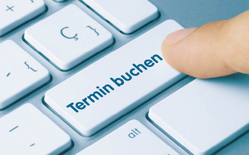 Ein Finger klickt auf die Taste "Termin buchen"